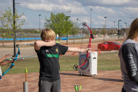 Kid shooting bow and arrow at Frontier Park in Prosper, Texas